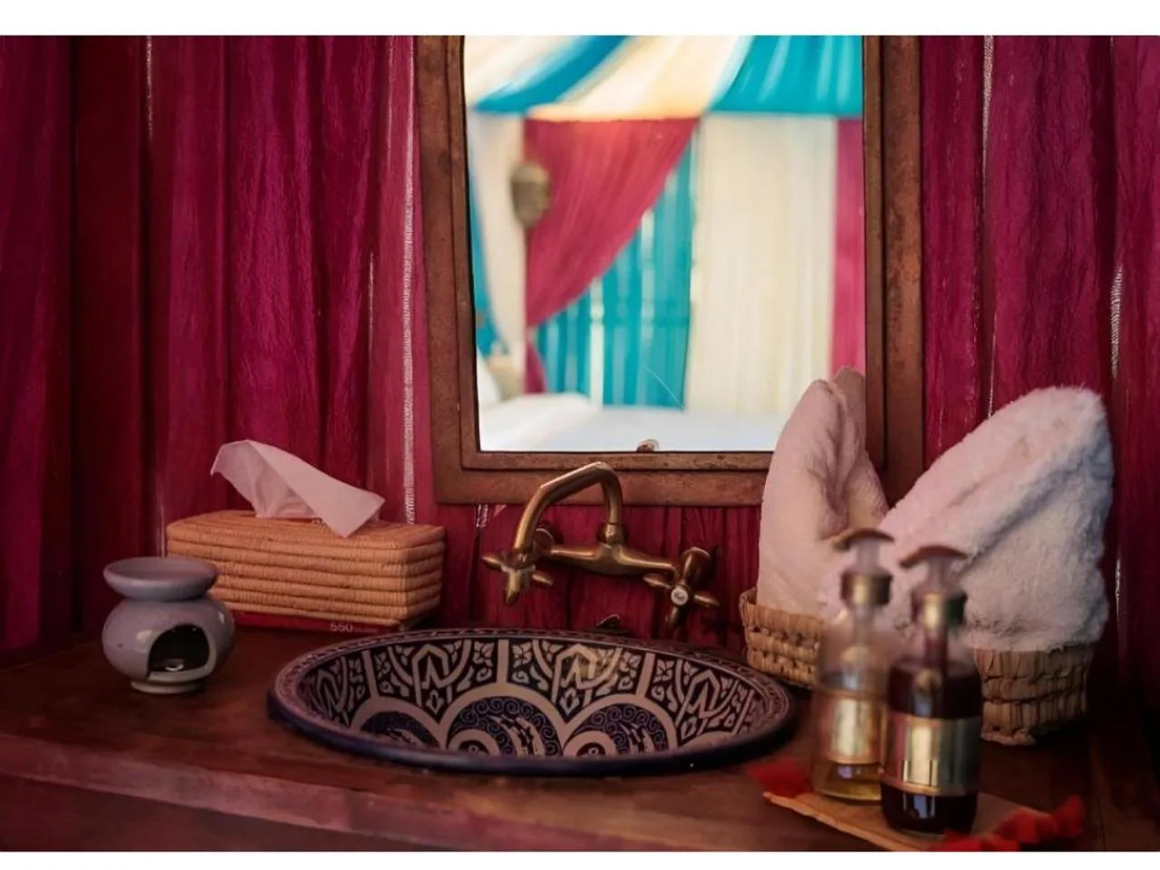 Meuble de salle de bains à Premium Luxury Camp à Merzouga avec lavabo décoratif, miroir, serviettes et articles de toilette