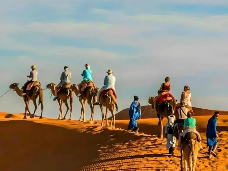 Touristes à dos de chameau dans le désert du Sahara près de Premium Luxury Camp à Merzouga