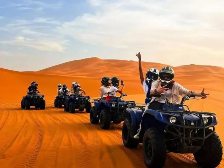 Groupe de voyageurs en quad traversant le désert près de Premium Luxury Camp à Merzouga