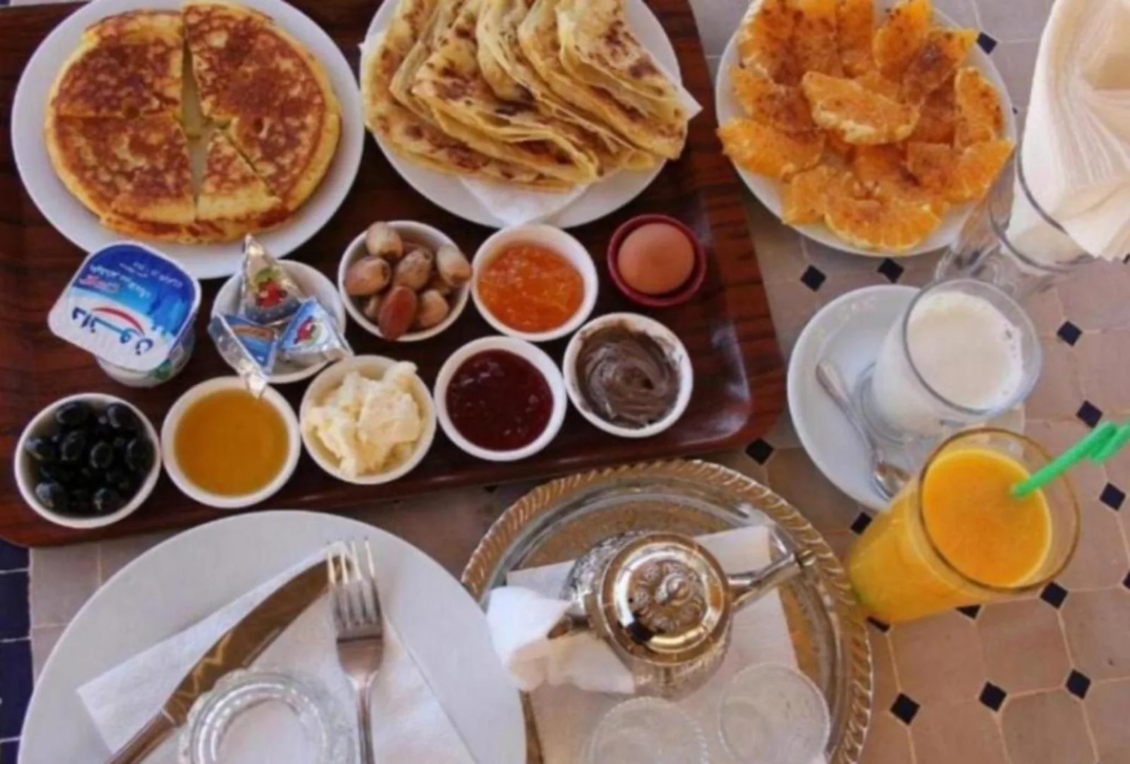 Mesa de desayuno en Prime Luxury Camp en Merzouga con pasteles marroquíes y bebidas