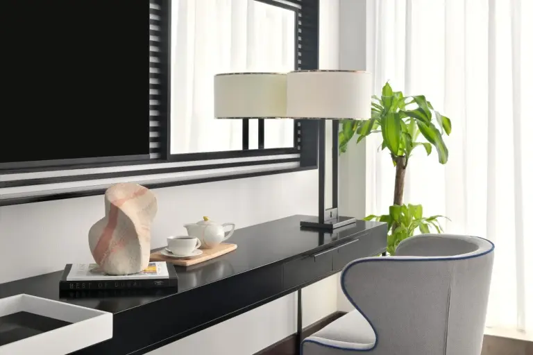 Rincón de trabajo en Pullman Dubai Downtown en Dubai con escritorio, lámpara, silla y amenities