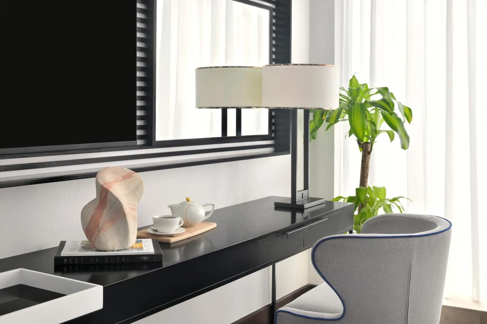 Rincón de trabajo en Pullman Dubai Downtown en Dubai con escritorio, lámpara, silla y amenities