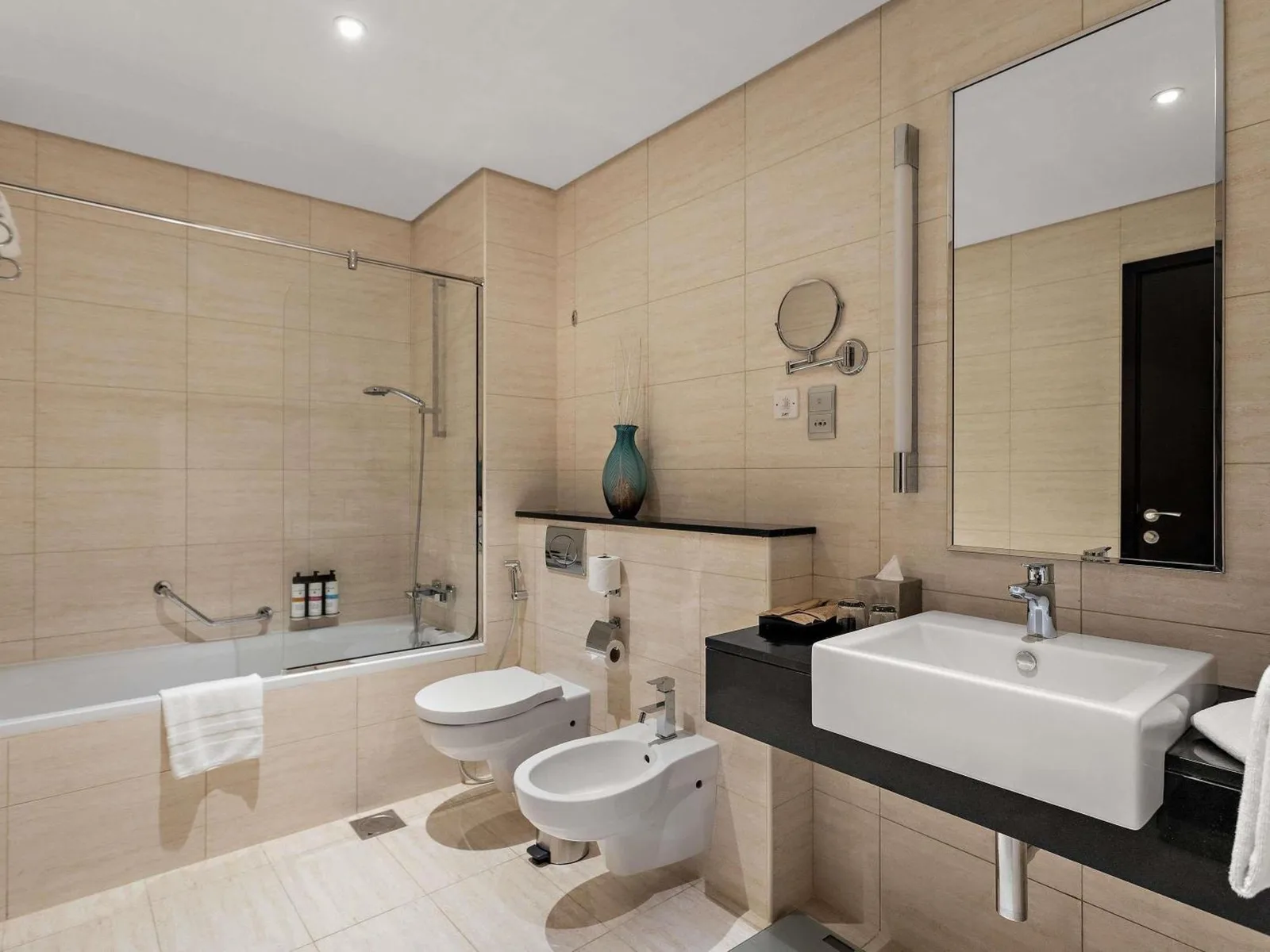 Salle de bains moderne au Pullman Dubai Jumeirah Lakes Towers à Dubai avec douche à l'italienne, lavabo et toilettes