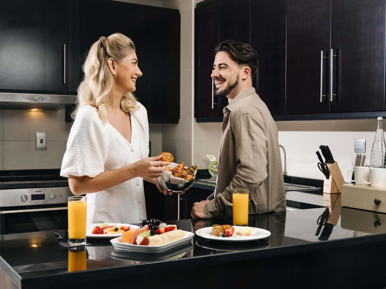 Couple prenant le petit-déjeuner dans une cuisine moderne au Pullman Dubai Jumeirah Lakes Towers à Dubai