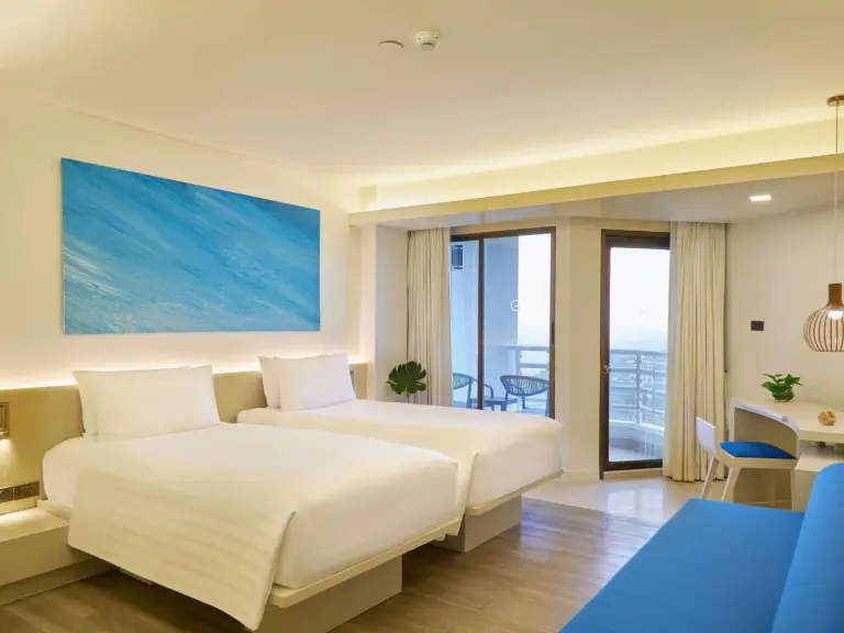 Pullman Pattaya Hotel G – hôtel à Pattaya, Thaïlande – une chambre d’hôtel avec deux lits et un bureau au Pullman Pattaya Hotel G à Pattaya North
