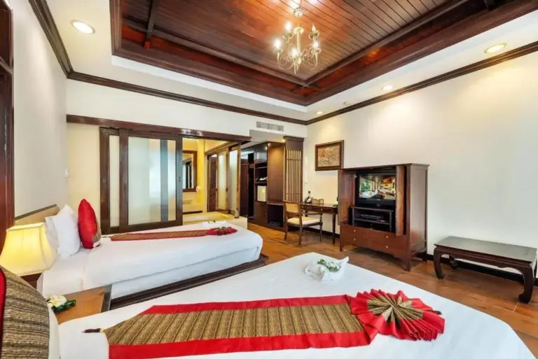 Twin bedroom at Racha Kiri Resort & Spa in Khanom, Nakhon Si Thammarat, with wooden decor and warm lighting.