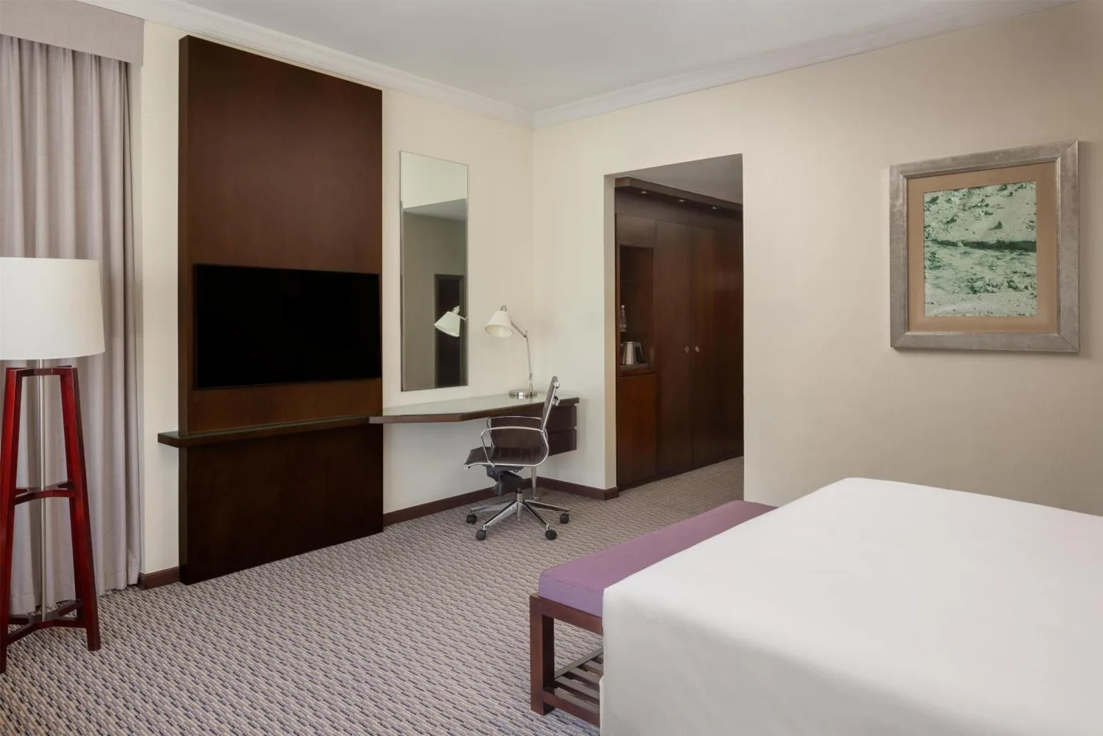 Salle de bains au Radisson Blu Hotel, Dubai Barsha Heights avec baignoire, douche à l’italienne, lavabo et stores aux fenêtres.