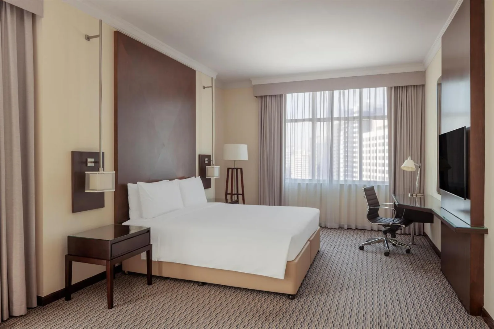 Chambre guest King au Radisson Blu Hotel, Dubai Barsha Heights avec grand lit, bureau et fenêtre lumineuse.