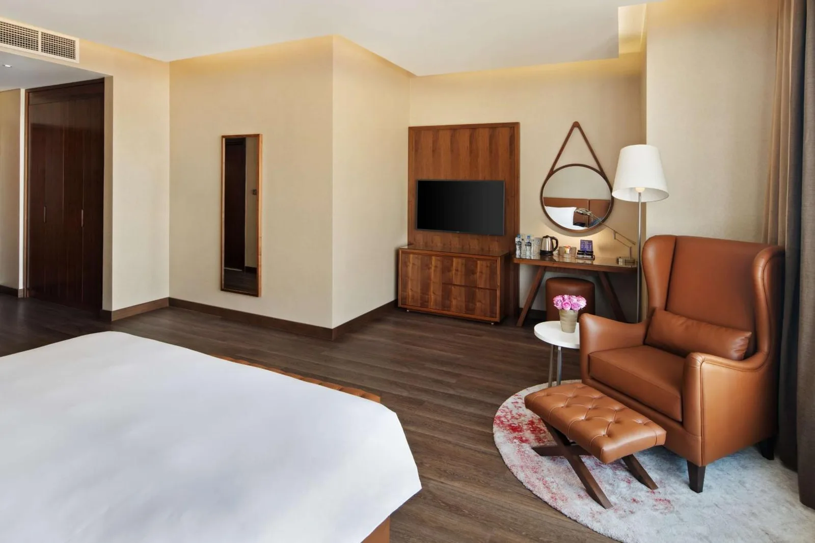 Guest room at Radisson Blu Hotel, Dubai Canal View with a bed, seating area, and modern wood furnishings