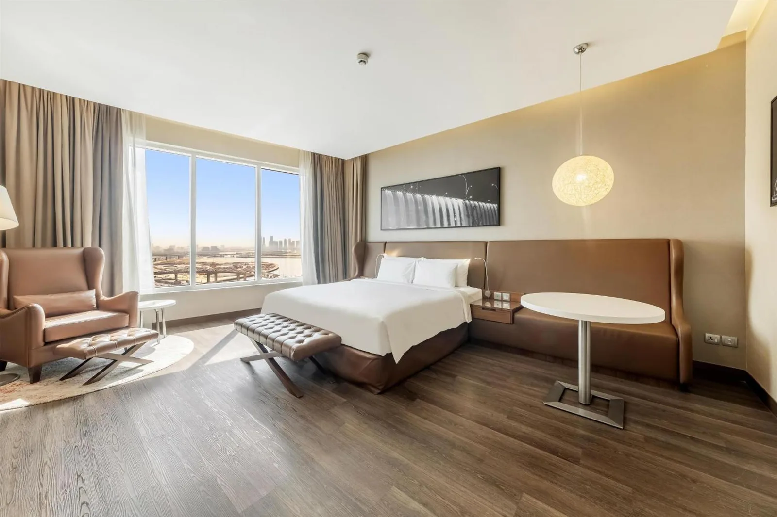 Spacious king guest room at Radisson Blu Hotel, Dubai Canal View with large windows and a city view