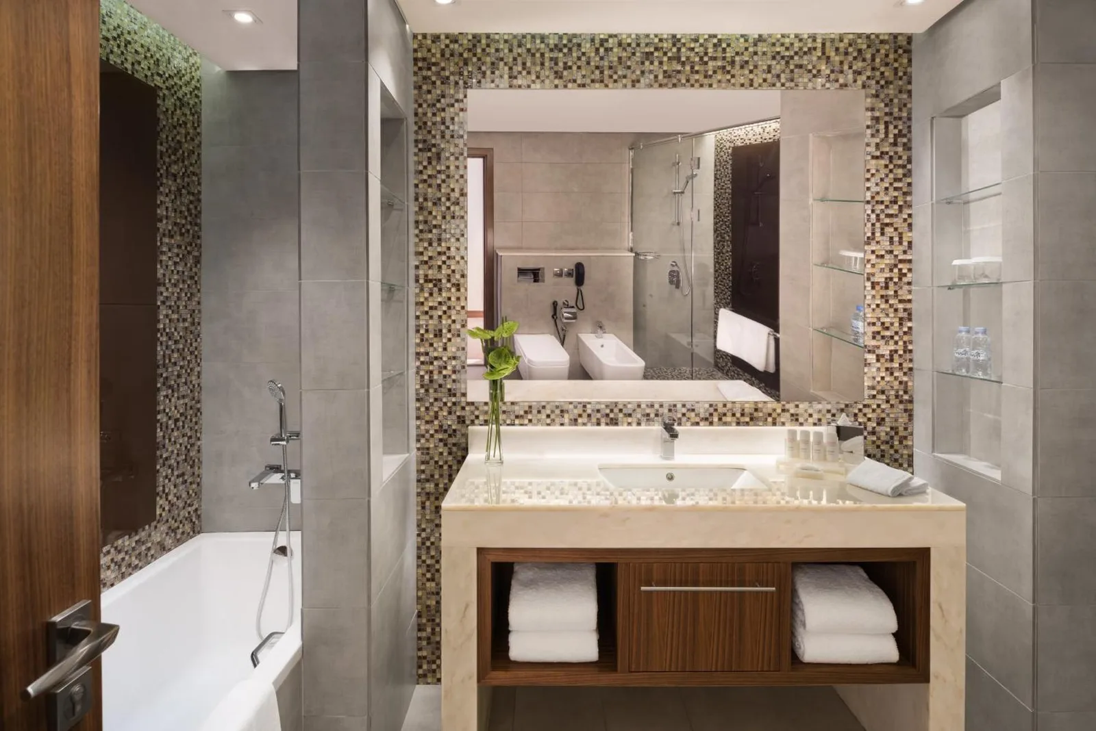 Baño en Radisson Blu Hotel, Dubai Waterfront en Dubai con bañera, lavabo con mueble, espejo y estantes de almacenaje