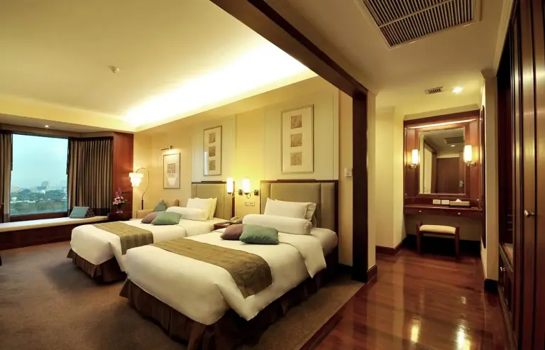 Suite con dos camas, zona de estar y vistas a la ciudad en Rama Gardens Hotel Bangkok