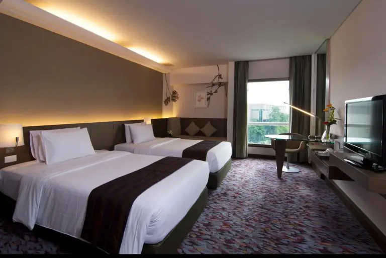 Habitación doble con dos camas individuales y vistas desde la ventana en Rama Gardens Hotel Bangkok