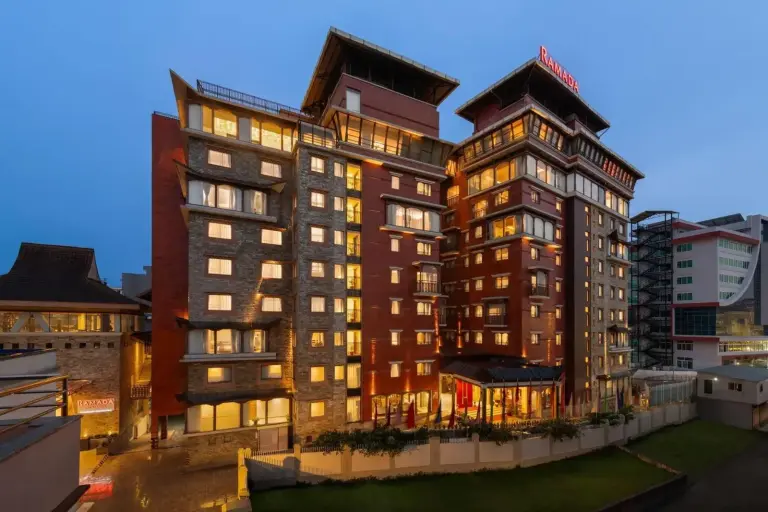 Vue extérieure du Ramada by Wyndham Kathmandu Dhumbarahi à Kathmandu au crépuscule, montrant le bâtiment de l’hôtel illuminé.