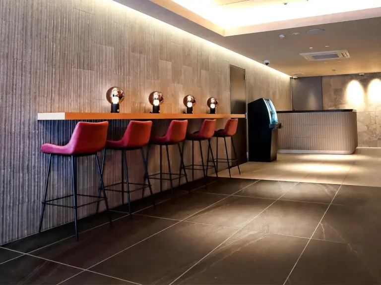 Stylish lobby bar area at RE Hotel Umeda-2 in Osaka with high stools and warm lighting.