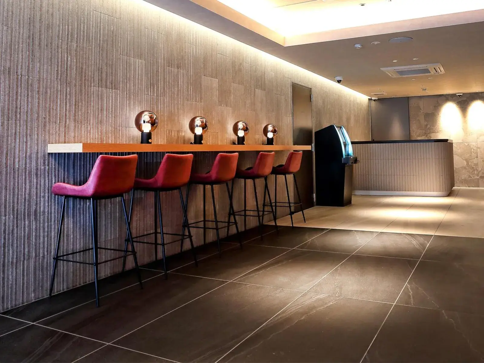 Stylish lobby bar area at RE Hotel Umeda-2 in Osaka with high stools and warm lighting.