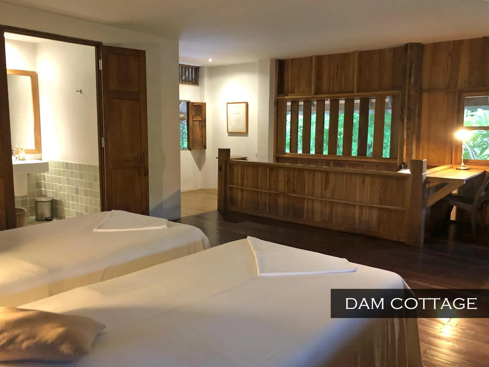 Dormitorio de Dam Cottage en Resort Hoshihana Chiang Mai con camas individuales e interior de madera