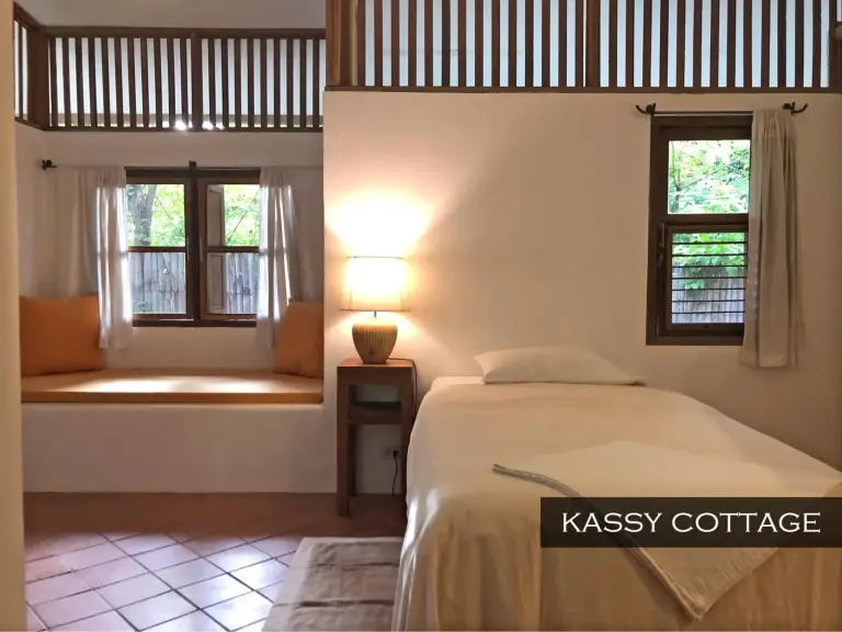 Dormitorio de Kassy Cottage en Resort Hoshihana Chiang Mai con cama individual y asiento empotrado junto a la ventana