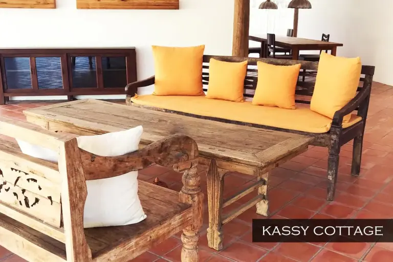 Salón de Kassy Cottage en Resort Hoshihana Chiang Mai con sofá rústico y mesa de centro de madera