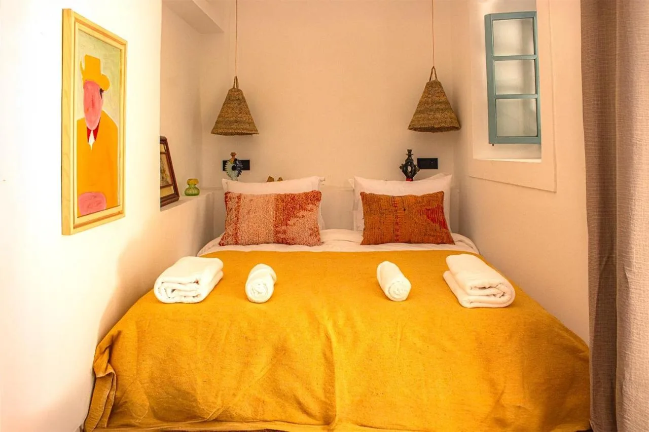 Riad Dar Ben Slimane – Hotel in Marrakesch, Marokko – ein Schlafzimmer mit gelbem Bett und Handtüchern im Riad Dar Ben Slimane in Marrakesch