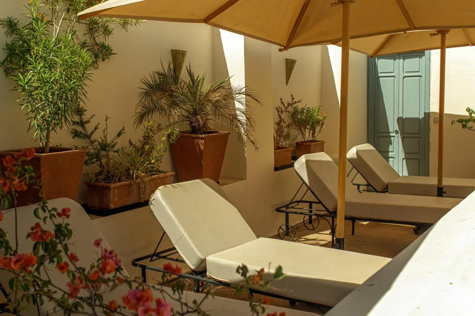 Riad Dar Ben Slimane in Marrakesch Dachterrasse mit Sonnenliegen, Topfpflanzen und einem schattigen Sitzbereich