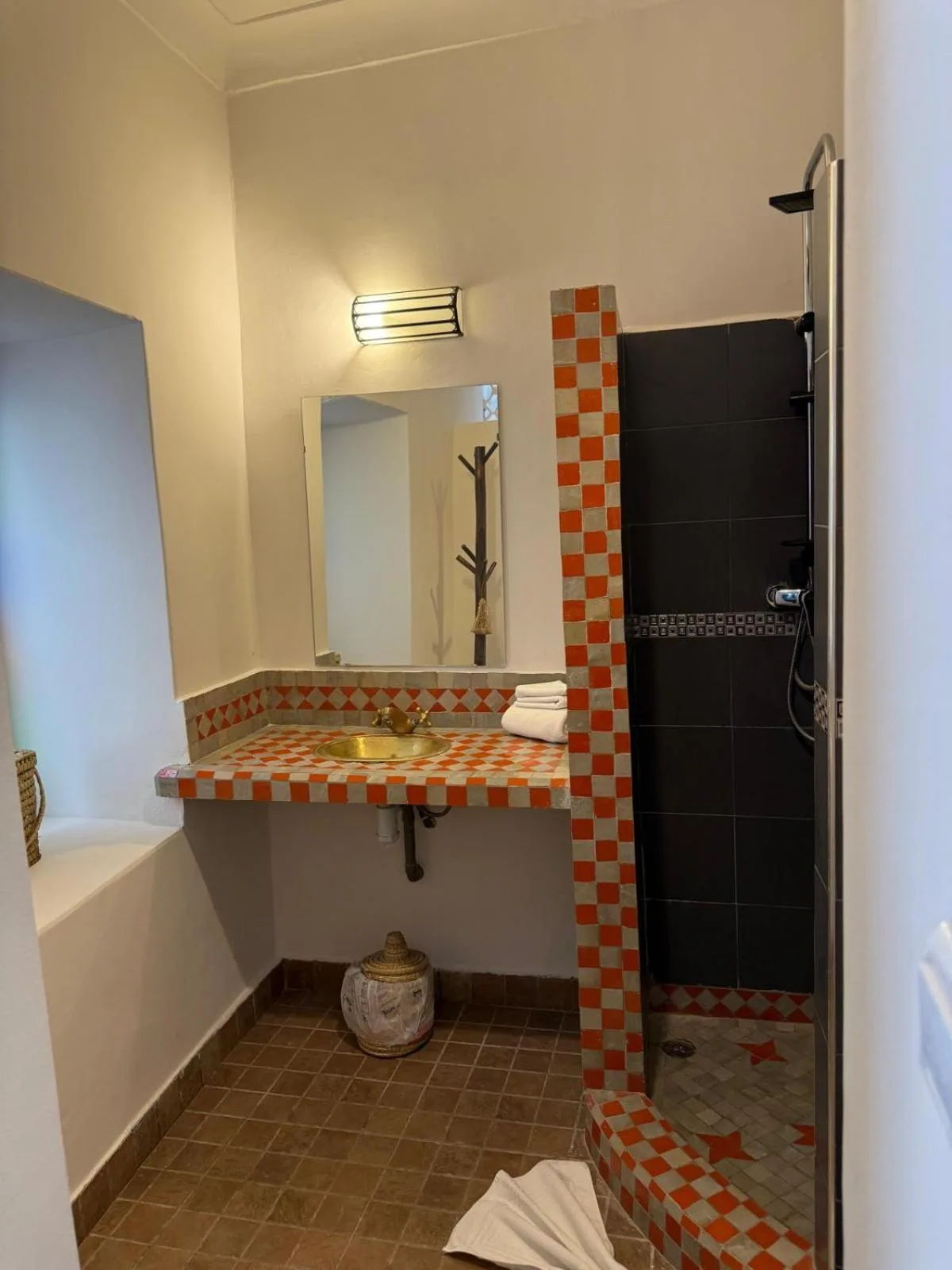 Waschbecken und Dusche im Badezimmer des Riad DIHYA & Rooftop Pool in Marrakesch mit Schachbrettfliesen