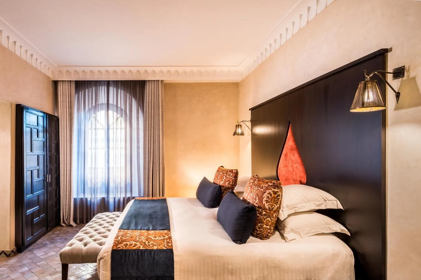 Riad Fes - Relais & Châteaux – Hotel in Fès, Marokko – ein Schlafzimmer mit einem großen Bett und einer großen Kopfstütze im Riad Fes - Relais & Châteaux in Fès