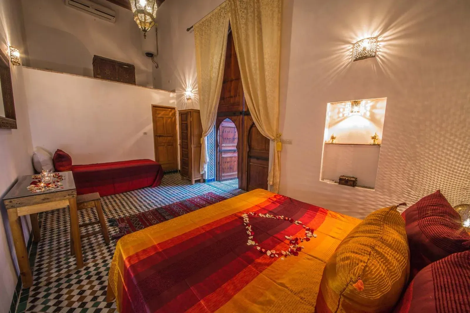 Habitación doble en Riad Gzira Fez en Fes con decoración tradicional, cortinas drapeadas y textiles coloridos