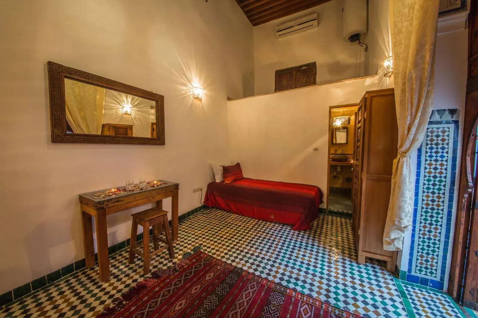 Acogedora habitación individual en Riad Gzira Fez en Fes con suelo de baldosas estampadas y decoración marroquí sencilla