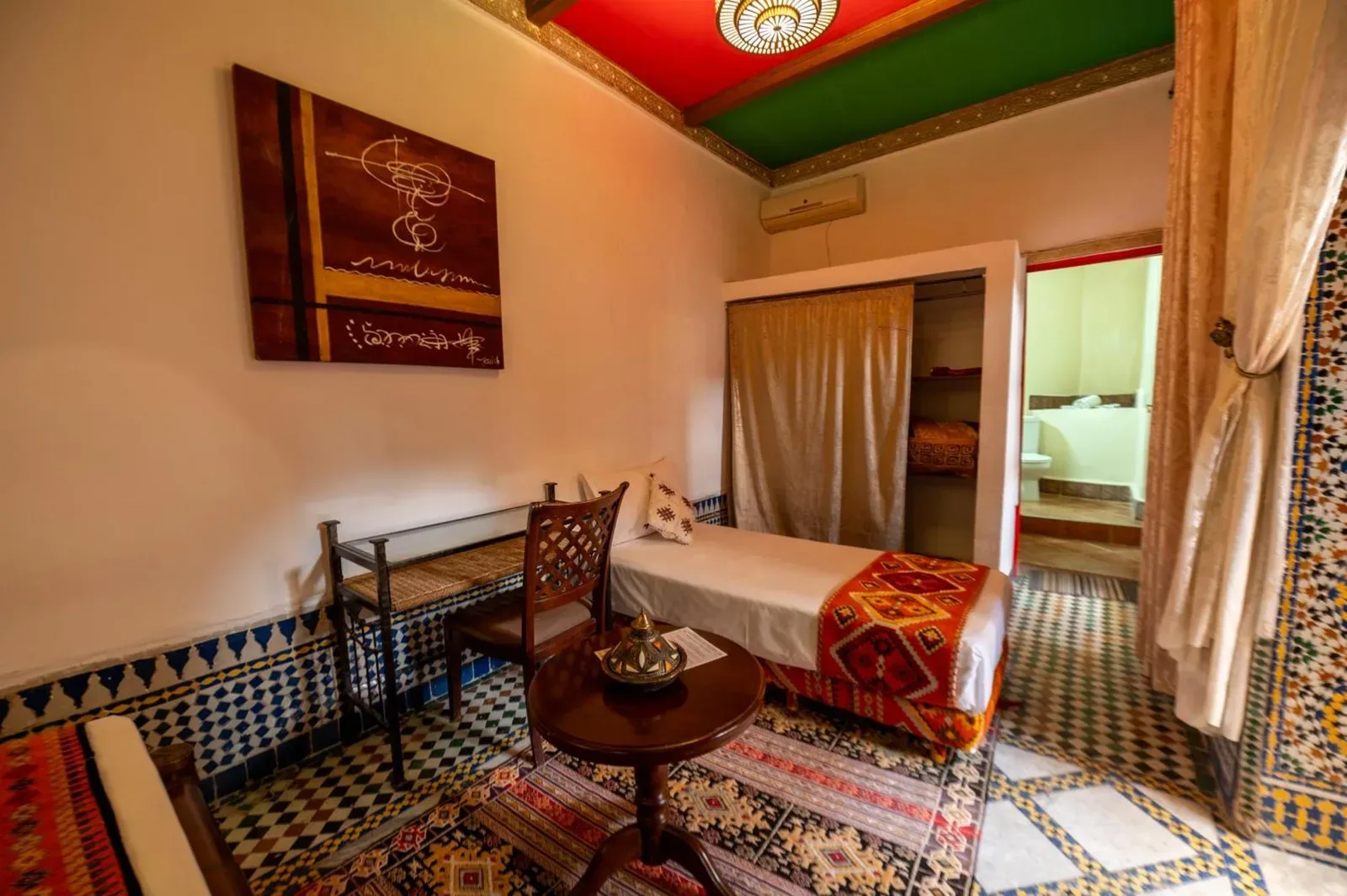 Habitación twin en Riad Lhaj Luxury Palace en Fes con techo estampado, cama individual y zona de estar