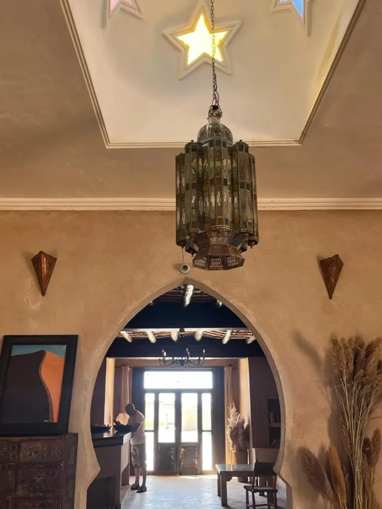 Reception area of Riad Suerteloca Merzouga with intricate lighting