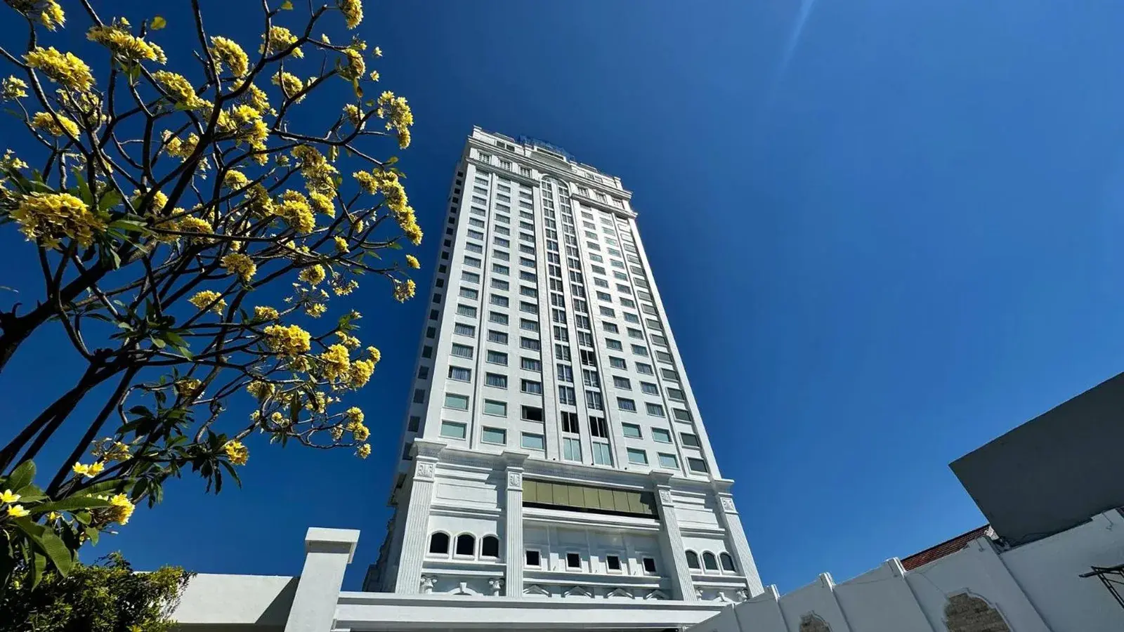 Vue extérieure de Rich Palace Hotel Surabaya sous un ciel bleu dégagé
