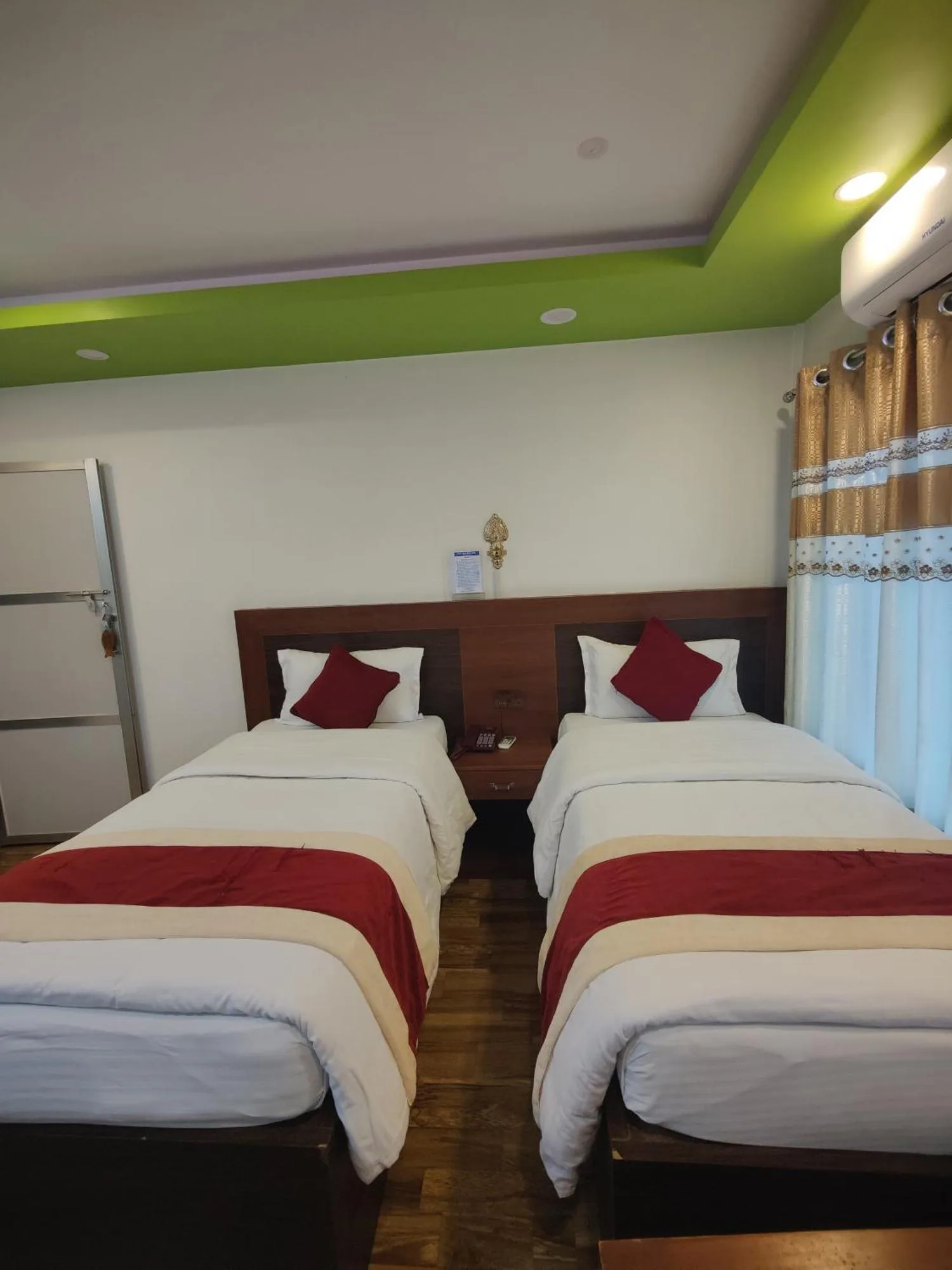 Dormitorio twin en River Side Hotel Pvt Ltd en Bandipur con dos camas individuales, ventanas con cortinas e iluminación de techo
