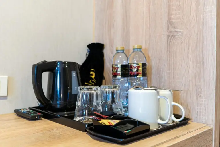 Rodina Beach Hotel Pattaya in-room amenities tray with kettle, cups, bottled water, and tea service