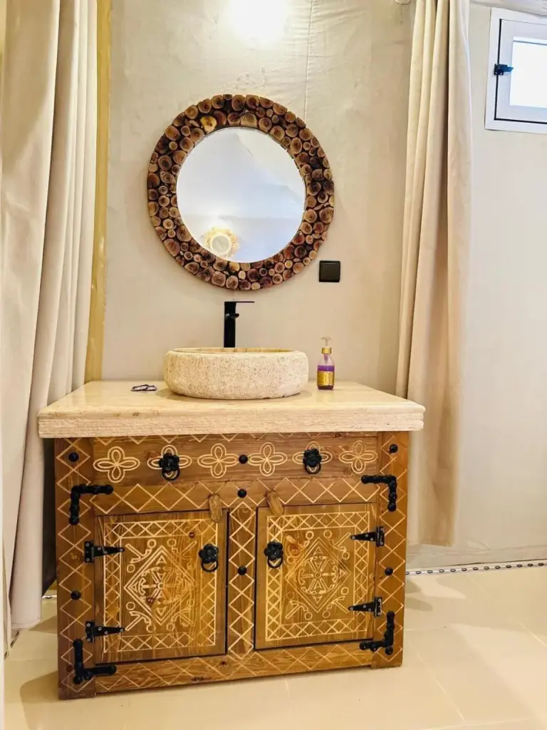 Rosara Luxury Camp in Merzouga bathroom vanity with carved cabinet and round mirror