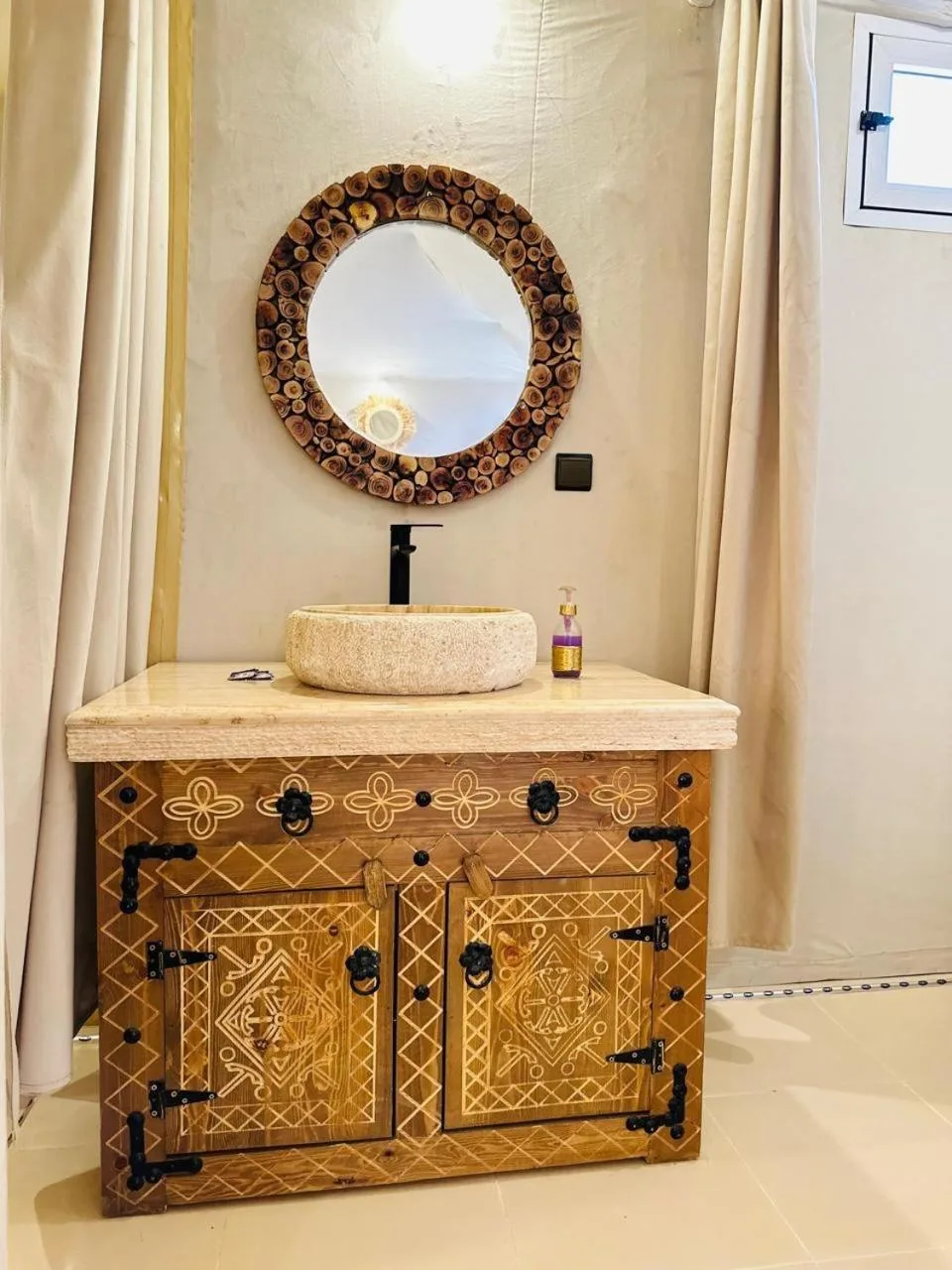 Rosara Luxury Camp in Merzouga bathroom vanity with carved cabinet and round mirror