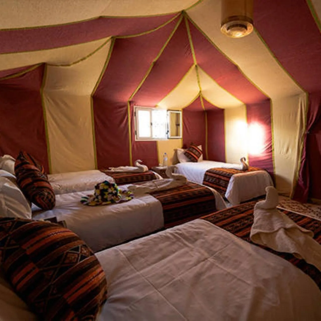 Rosara Luxury Camp in Merzouga large tent room with four beds and Moroccan-style textiles