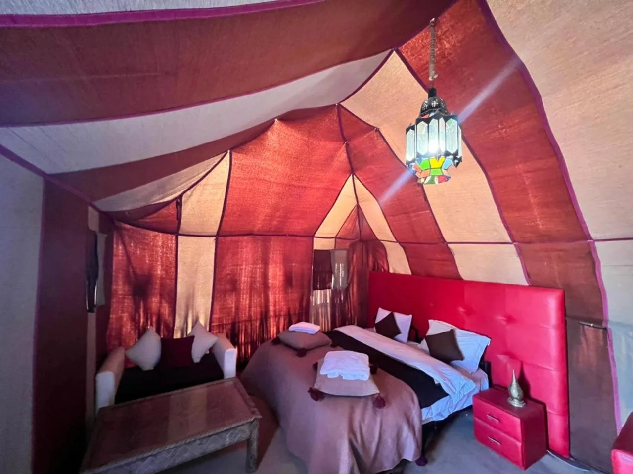 Roses desert camp in Merzouga luxury tent bedroom with red headboard, twin beds, and Moroccan decor
