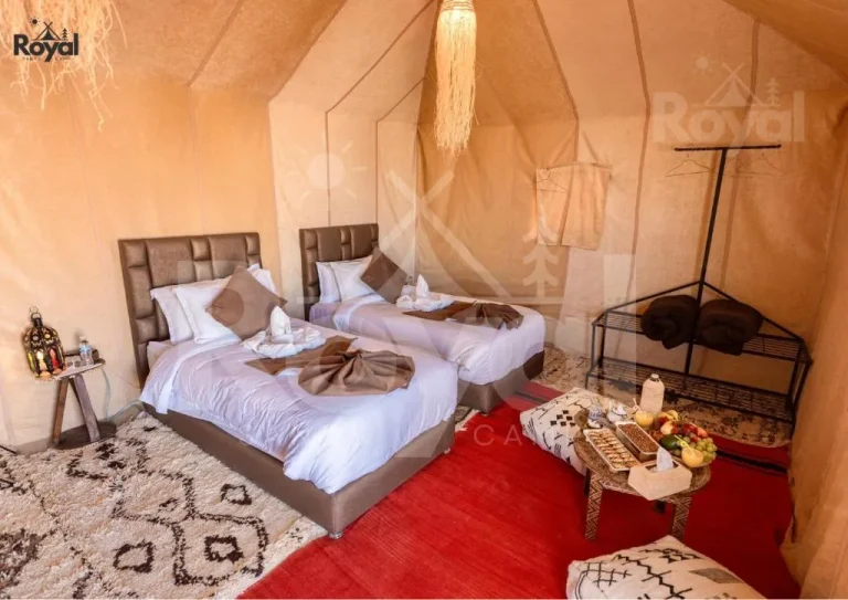 Einrichtung mit zwei Einzelbetten in einem luxuriösen Zelt im Royal Sands Camp in Merzouga