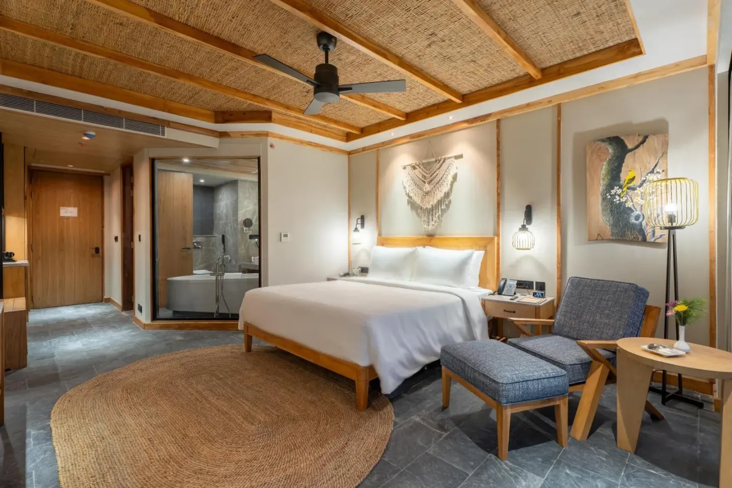 Habitación deluxe en Royal Tulip Chitwan Nepal en Sauraha con cama, zona de estar y acceso al baño