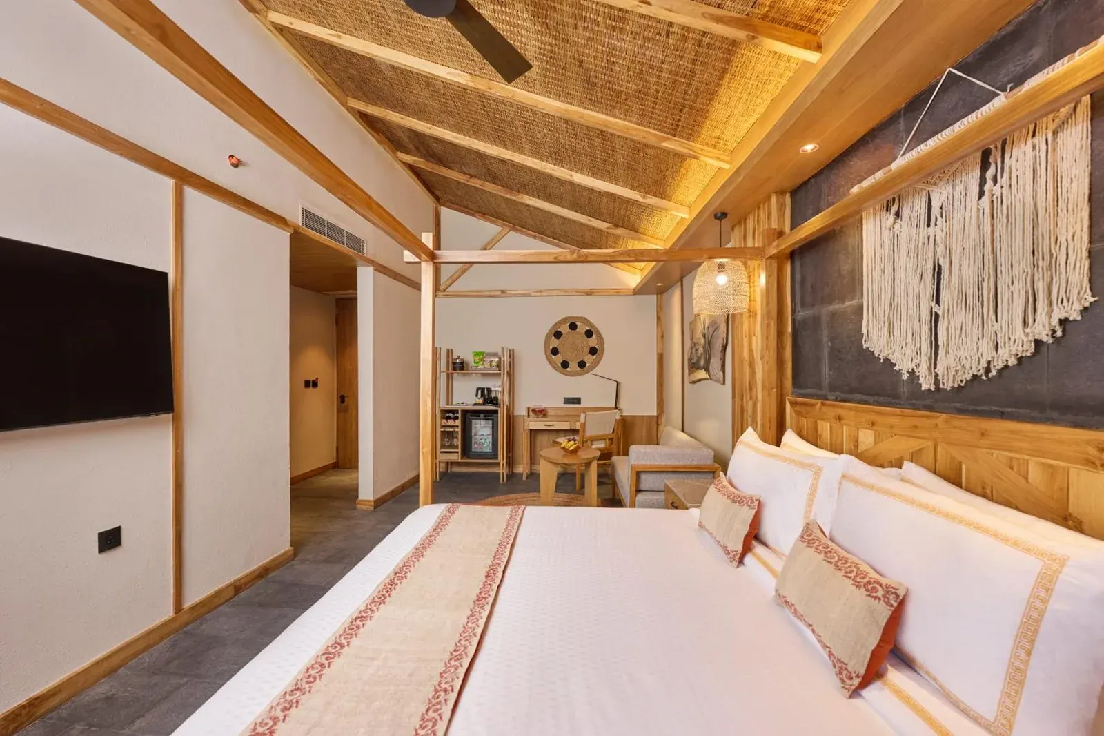 Interior de una habitación de huéspedes en Royal Tulip Chitwan Nepal en Sauraha con una cama king y una decoración cálida y lujosa