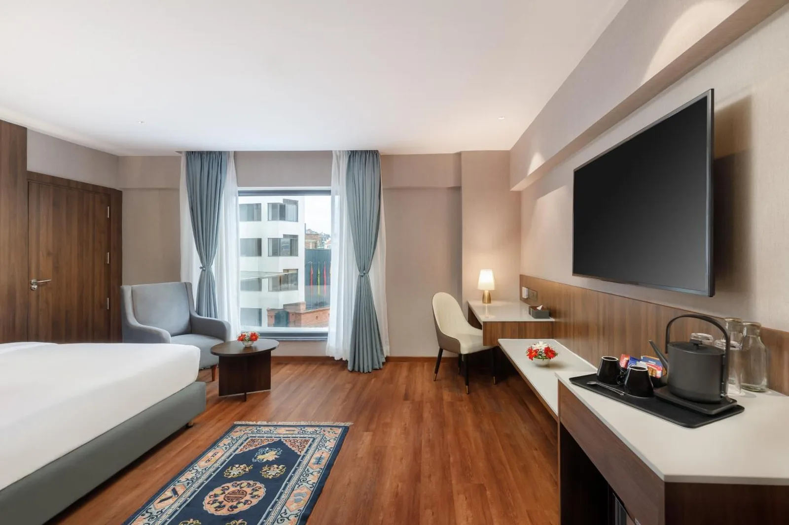 Spacious king room at Royal Tulip Kathmandu with work desk, TV, and bed