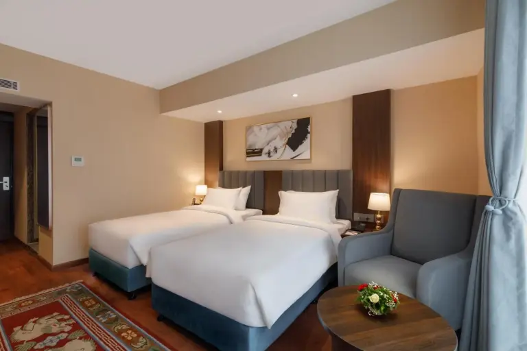 Twin room at Royal Tulip Kathmandu with window view, desk, and television