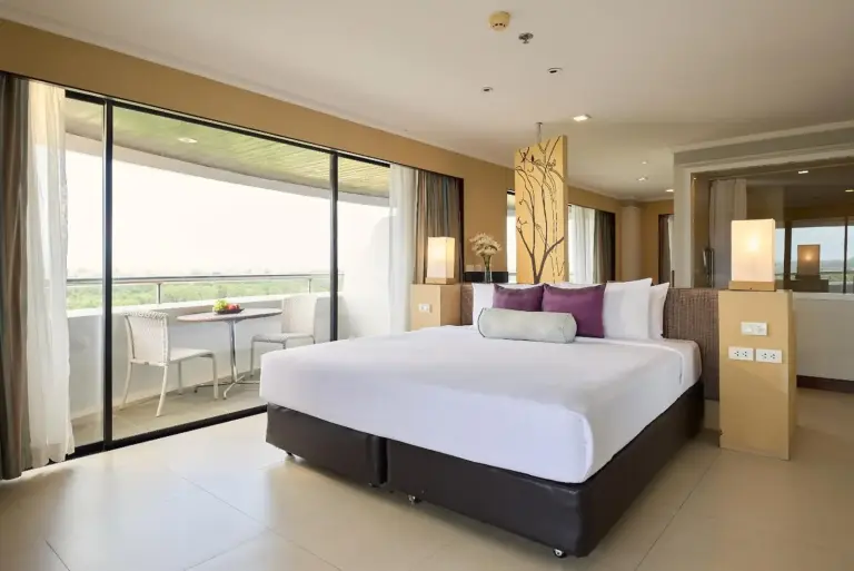 Vue intérieure d'une chambre deluxe au Rua Rasada Hotel avec un lit et un balcon