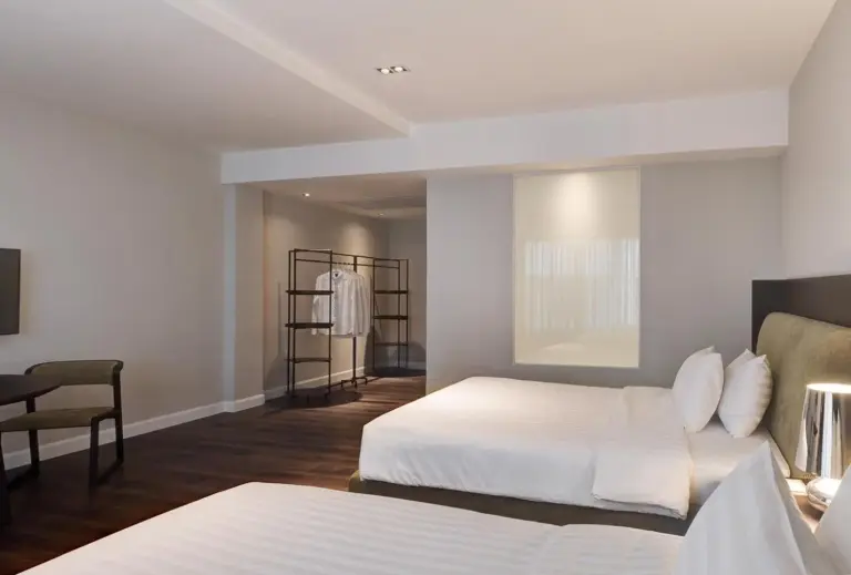 Zweibettzimmer im S Ram Leisure Hotel Bangkok mit zwei Betten, Schreibtisch und großem Fenster