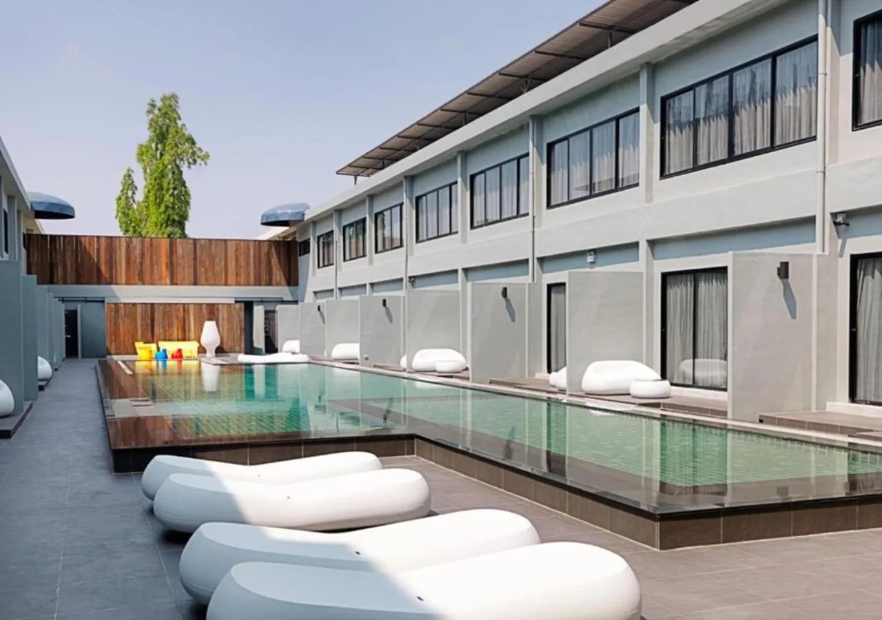 Suite Deluxe en S Ratchada Leisure Hotel en Bangkok con una cama king, zona de estar y acceso al balcón