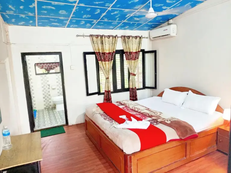 Habitación doble en Safariwildlife Lodge & Camp en Sauraha con una cama grande y acceso a baño privado