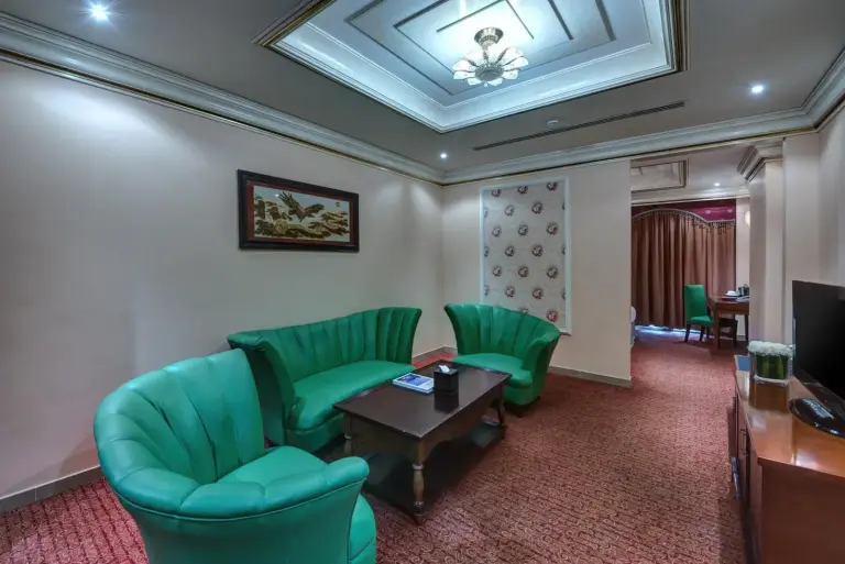 Coin salon à Sahara Beach Resort & Spa Sharjah avec fauteuils verts et table basse