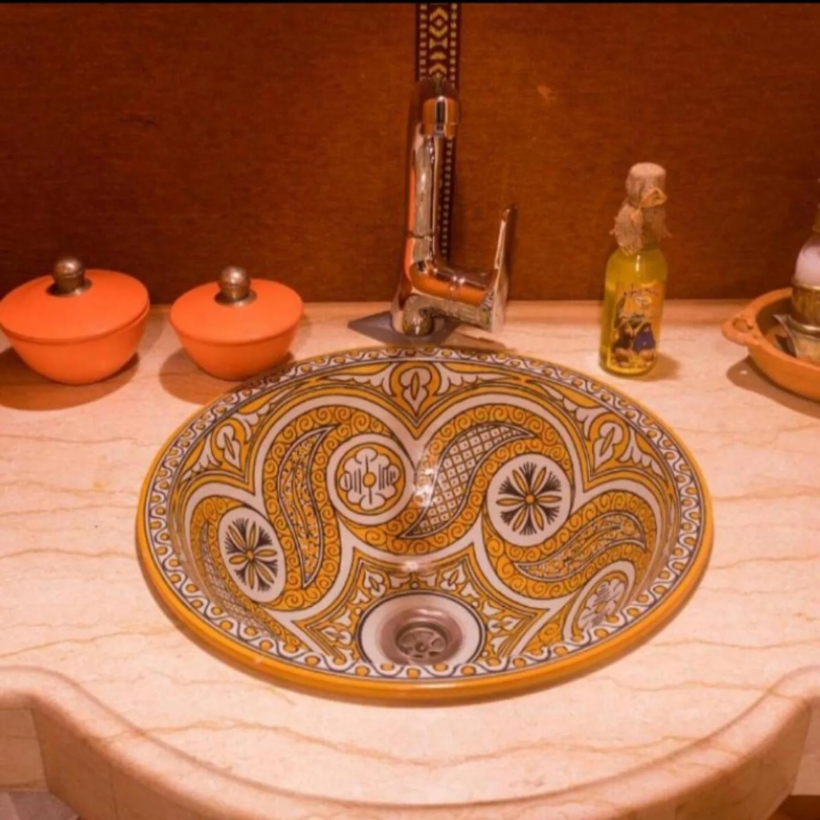 Colorful decorative bathroom sink at Sahara Luxe Camp in Merzouga with patterned basin and countertop accessories.