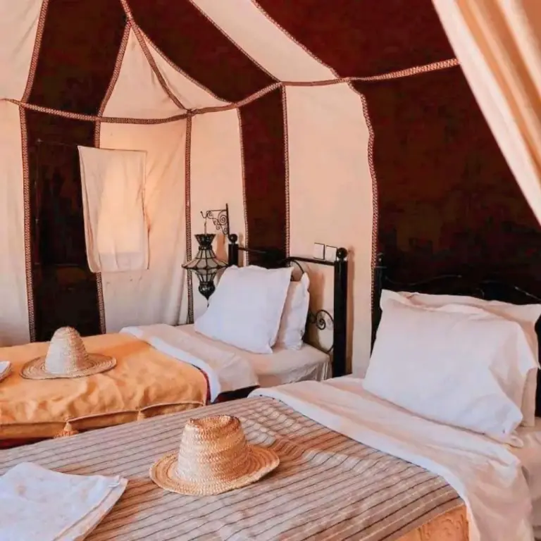 Sahara Luxe Camp – Merzouga, Morocco hotel – two beds in a room with hats on top of them at Sahara Luxe Camp in Merzouga